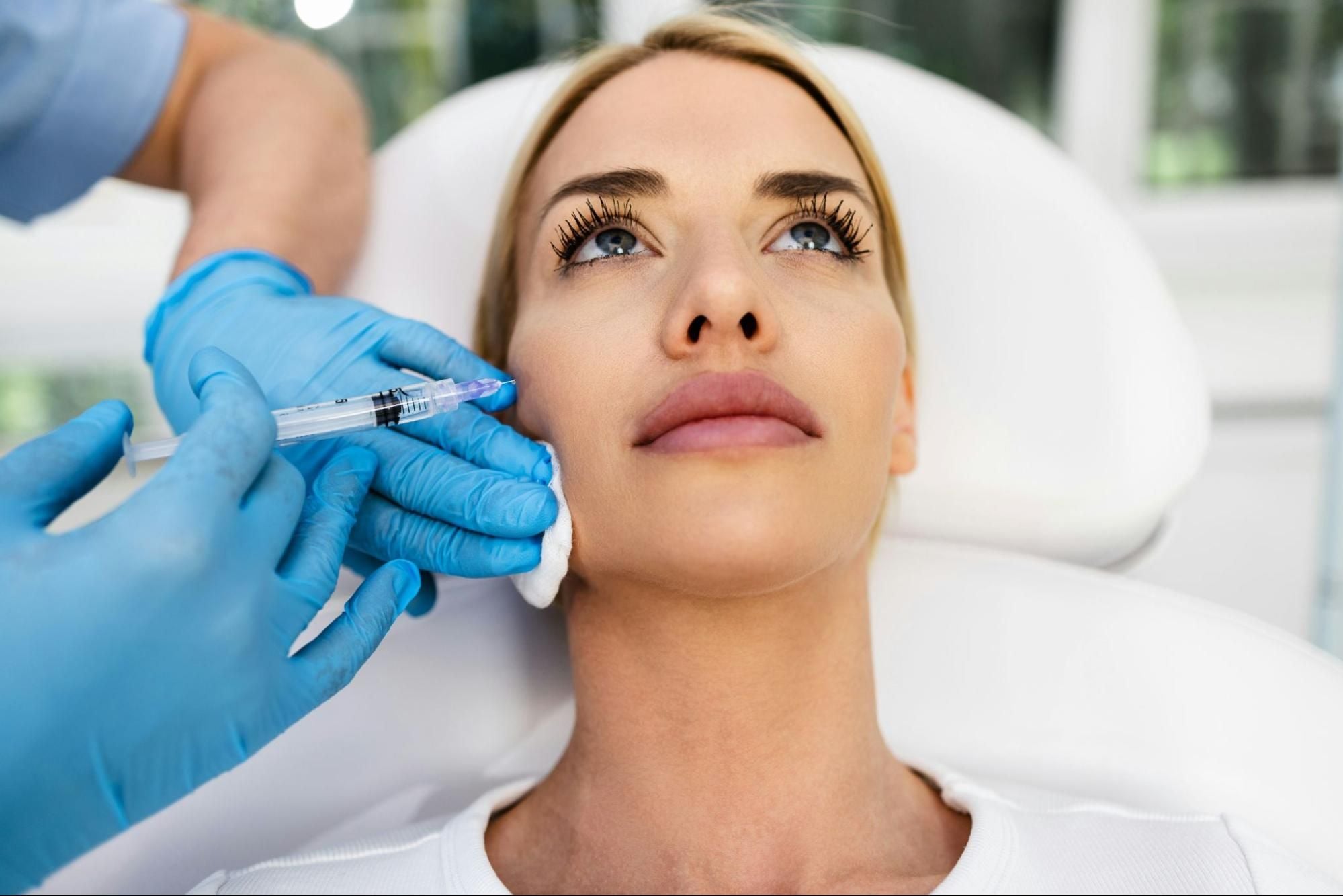 Blonde woman receiving a facial injection.